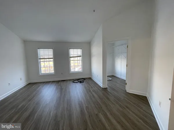 a room with hard wood floor and window