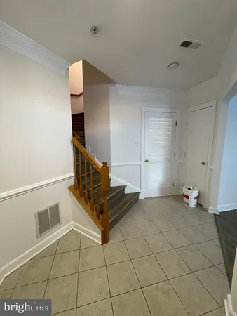 a view of an empty room and chandelier fan