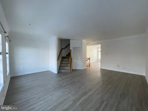 an empty room with wooden floor and stairs