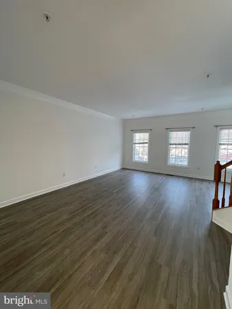 a view of empty room with window and wooden floor