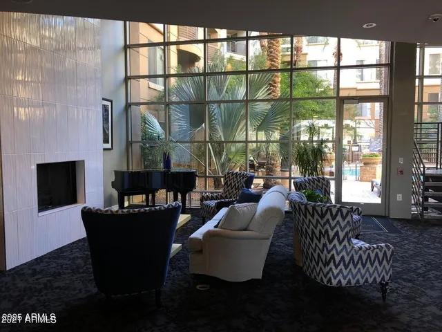 a living room with fireplace furniture and a floor to ceiling window