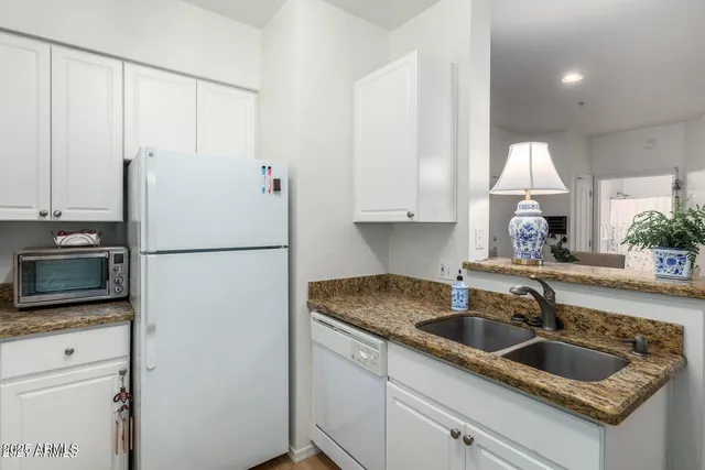 a kitchen with granite countertop a sink stainless steel appliances and cabinets