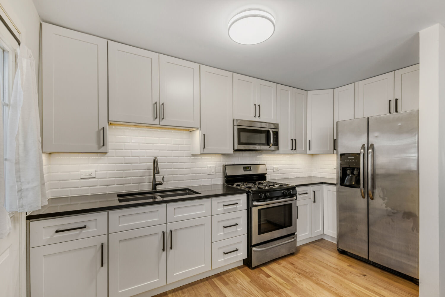 1710 Dempster Street, Unit B Park Ridge, IL 60068 - Photo 16 of 27 a kitchen with cabinets stainless steel appliances a sink and wooden floor
