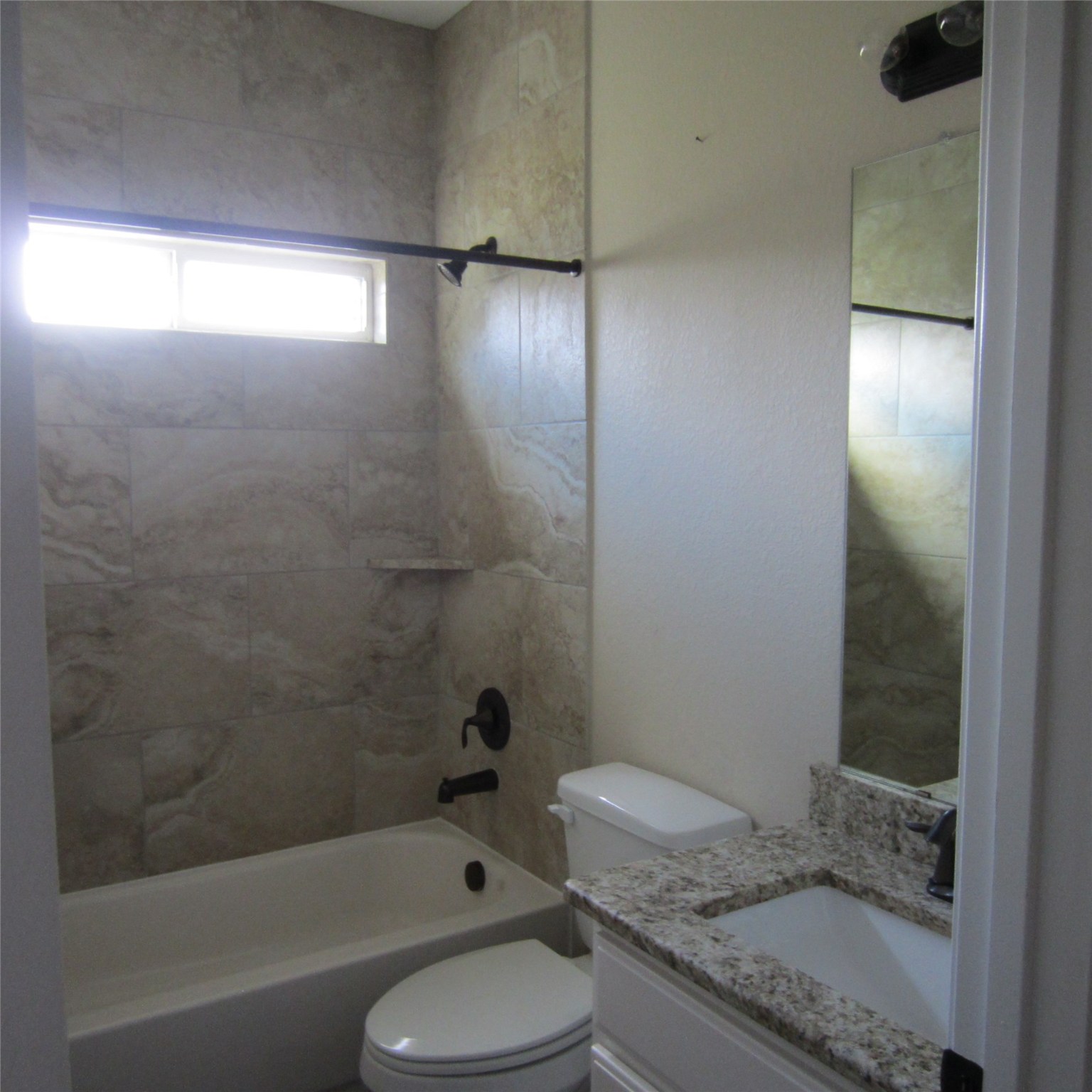 23431 Mcspadon Road, Unit 23415 Porter, TX 77365 - Photo 6 of 10 a bathroom with a granite countertop bathtub shower sink vanity and toilet