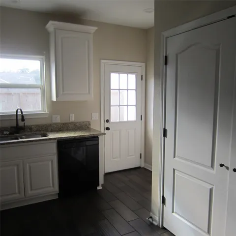 a kitchen with granite countertop white cabinets and sink
