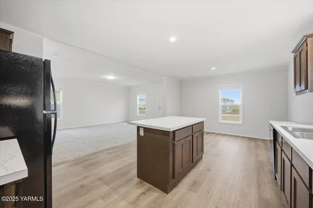 a kitchen with stainless steel appliances granite countertop a refrigerator a sink a stove and wooden floor