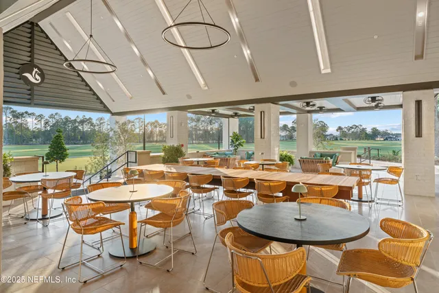 a living room with furniture a flat screen tv and a floor to ceiling window