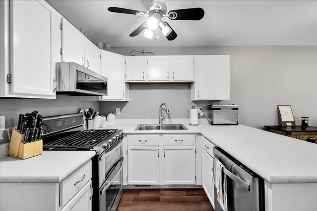 a kitchen with stainless steel appliances a sink a stove and cabinets