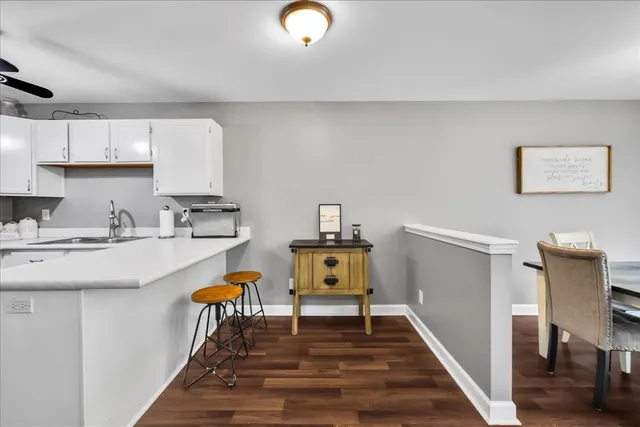a living room with furniture a rug and kitchen view