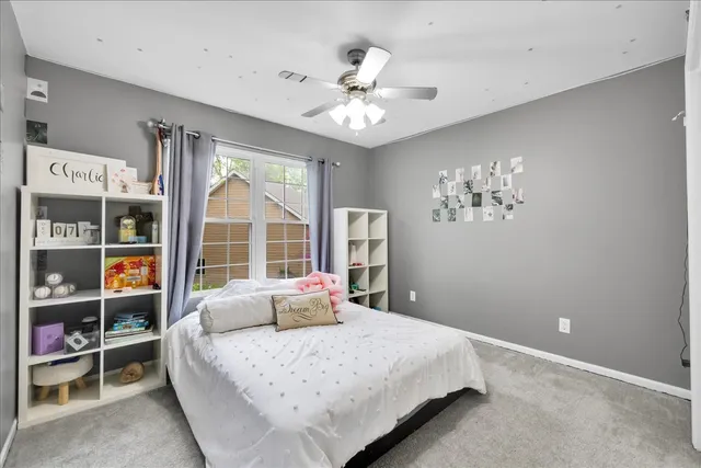 a bedroom with a large bed and a chandelier
