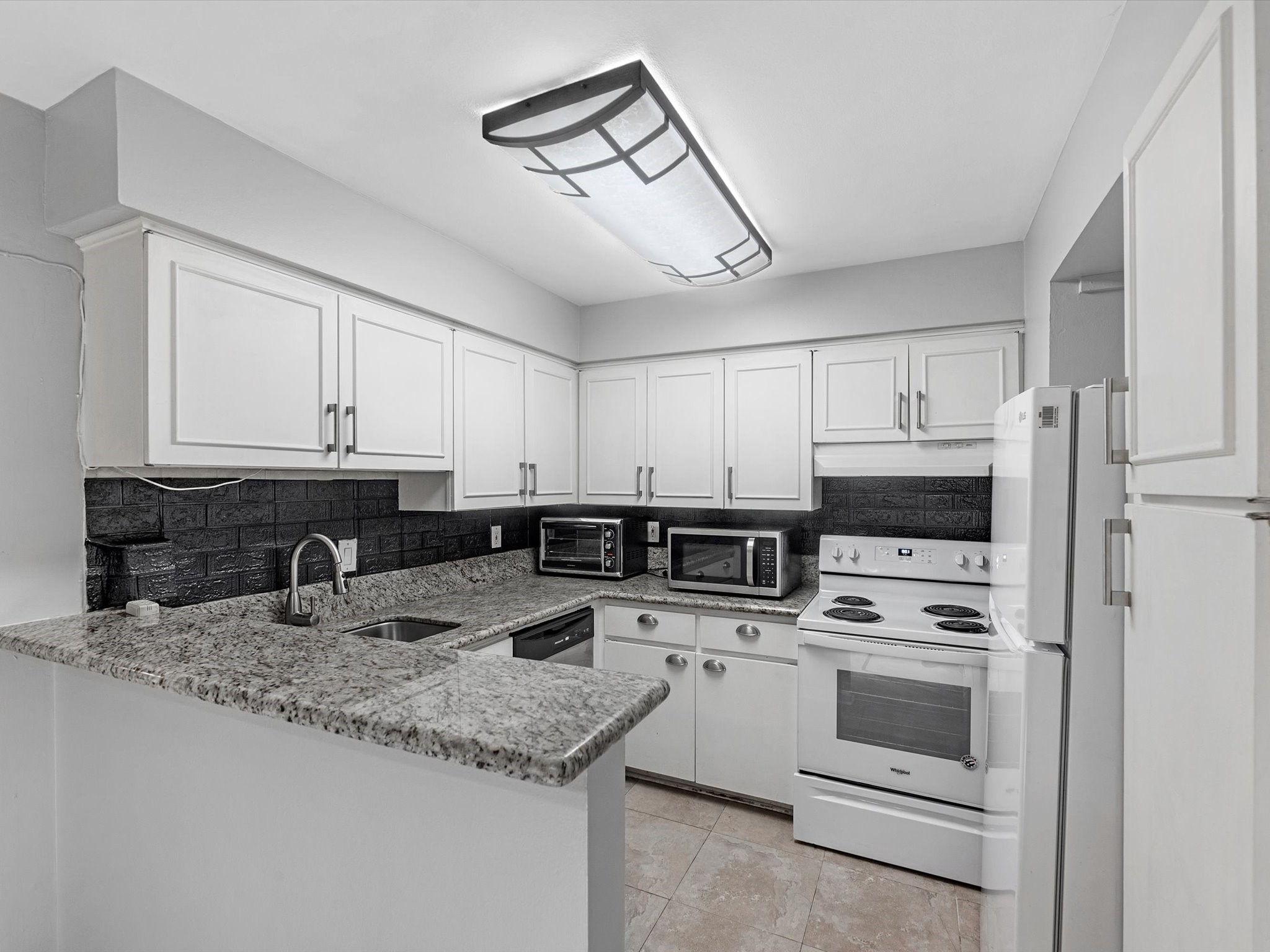 2647 Marilee Lane Houston, TX 77057 - Photo 11 of 26 a kitchen with granite countertop a sink stainless steel appliances and white cabinets