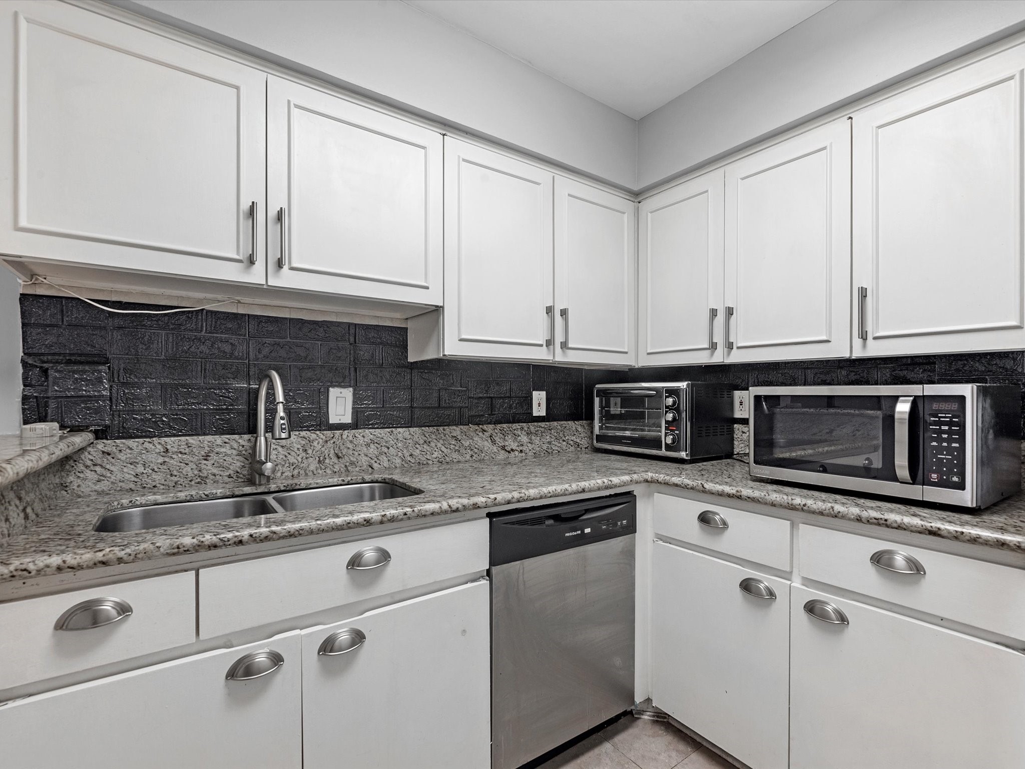 2647 Marilee Lane Houston, TX 77057 - Photo 12 of 26 a kitchen with granite countertop white cabinets and a sink