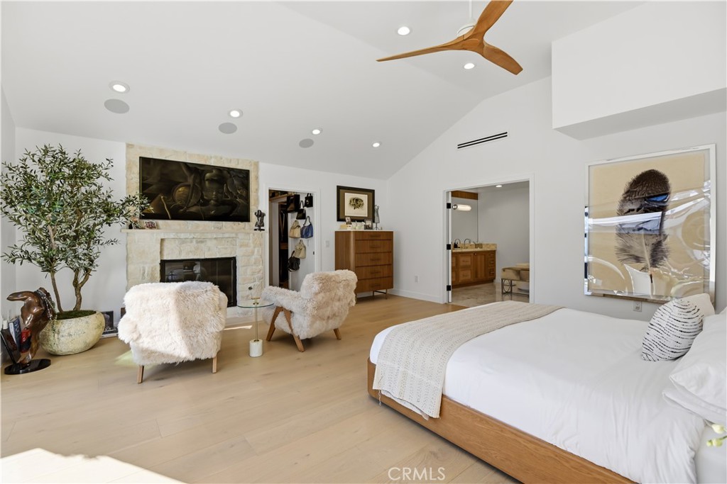 5565 Jed Smith Road Hidden Hills, CA 91302 - Photo 13 of 31 a bedroom with bed a flat screen tv and a fireplace with the potted plants