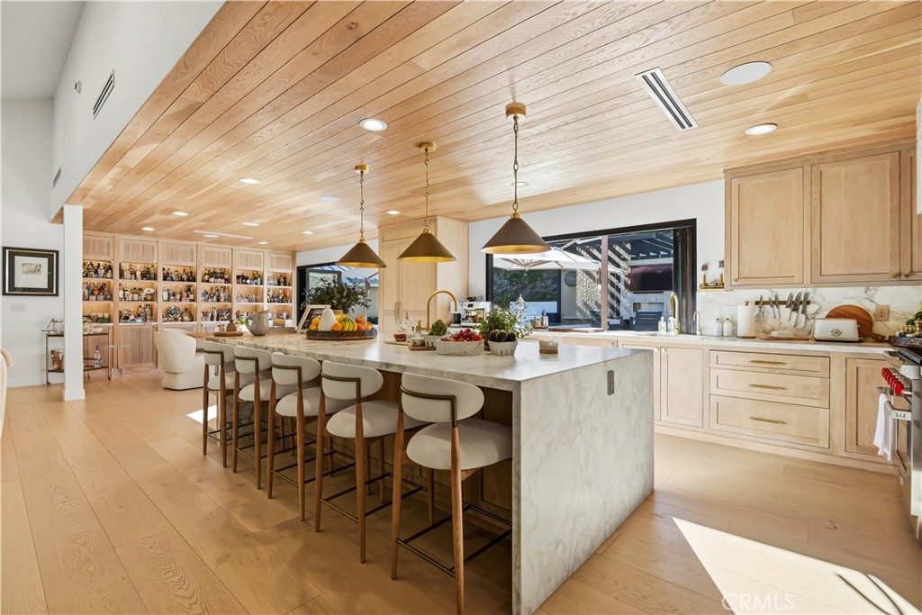 5565 Jed Smith Road Hidden Hills, CA 91302 - Photo 9 of 31 a kitchen with stainless steel appliances kitchen island granite countertop a table chairs sink and white cabinets