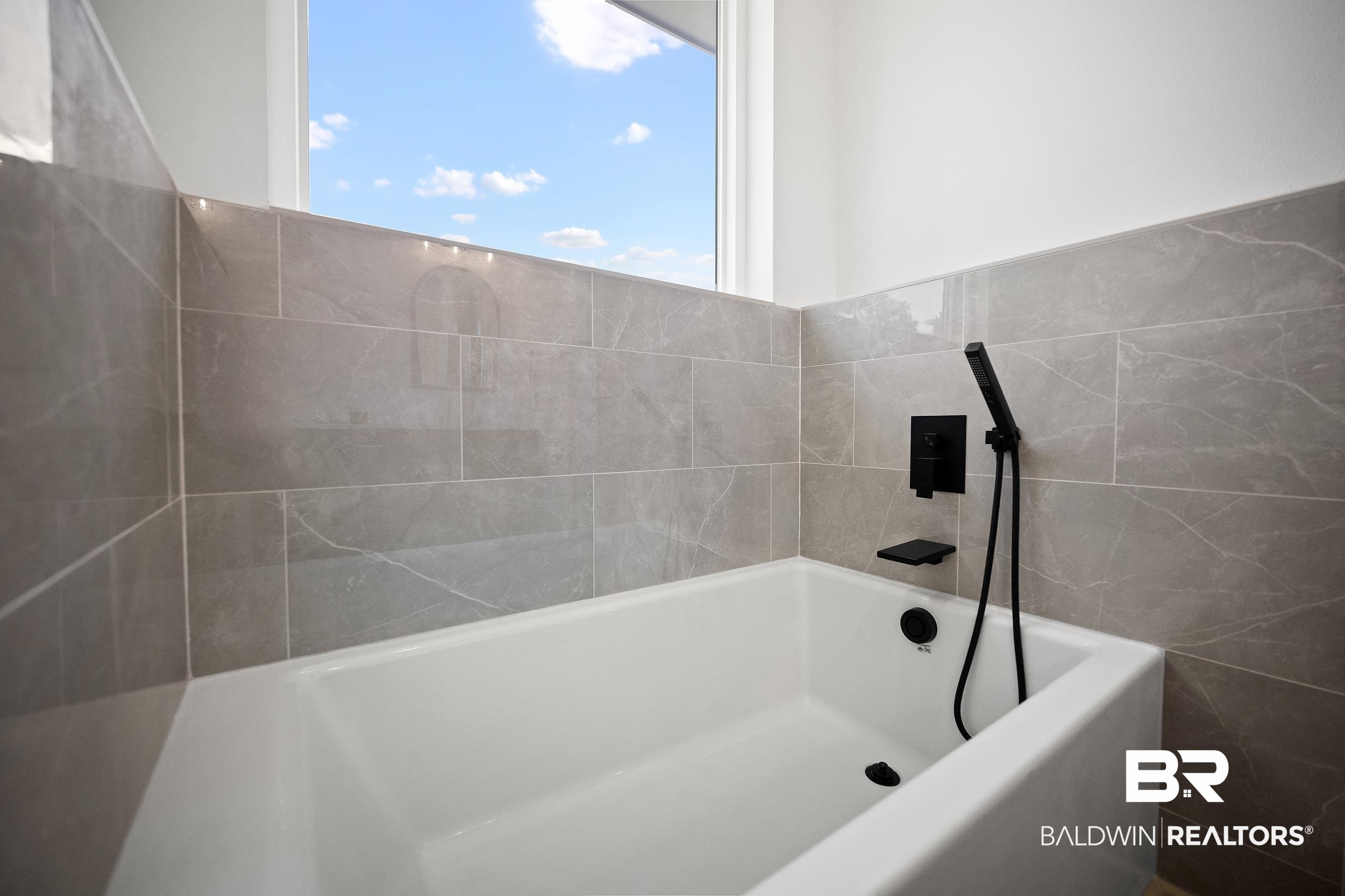 13111 Gopher Court Elberta, AL 36530 - Photo 20 of 41 Built-in soaking tub with matte black fixtures, a handheld shower, and a tiled surround