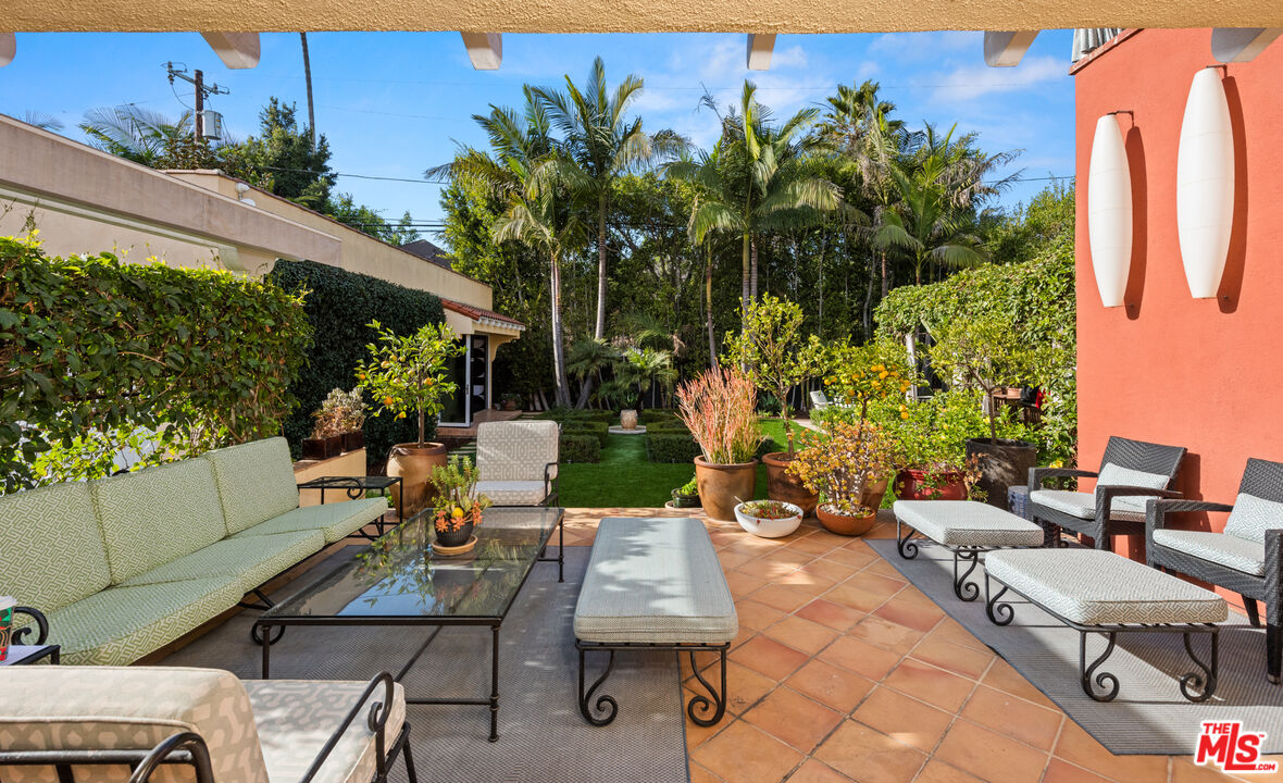 1663 Wellington Road Los Angeles, CA 90019 - Photo 30 of 45 a view of a patio with table and chairs potted plants and palm tree