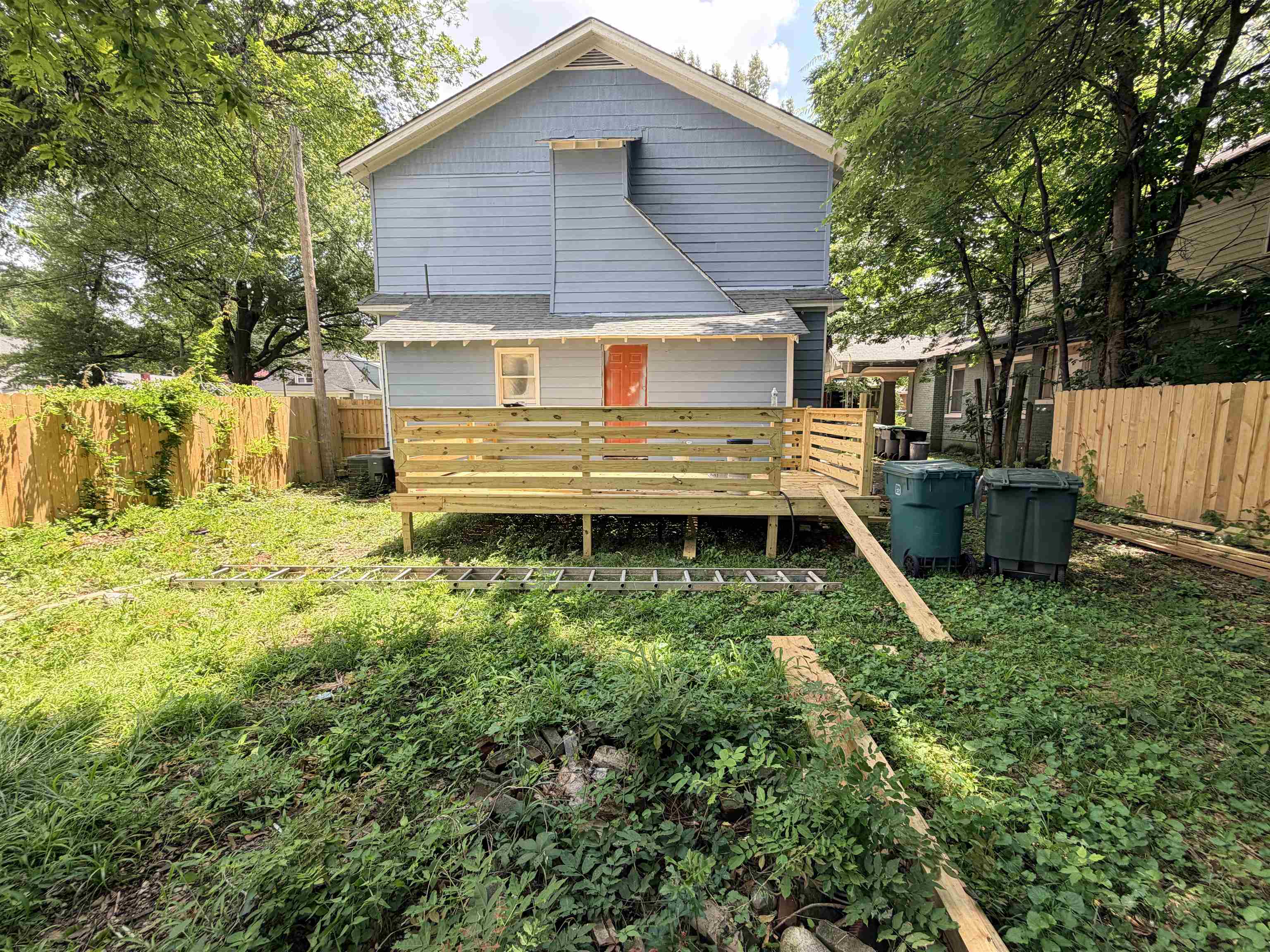 961 Meda Street Memphis, TN 38104 - Photo 25 of 27 Expansive backyard featuring a newly constructed wood deck, privacy fencing, and mature trees