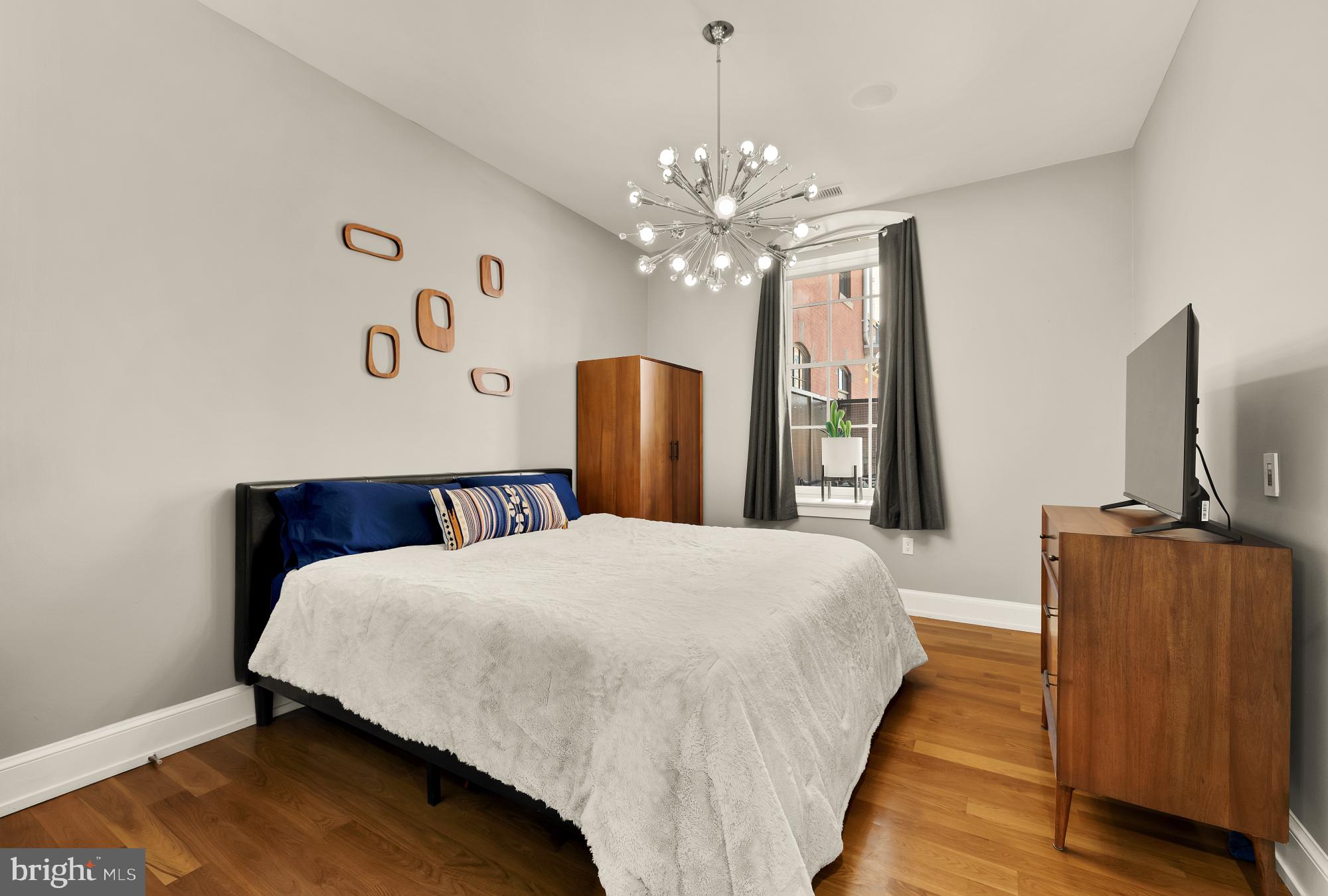 215 I Street Northeast, Unit 311 Washington, DC 20002 - Photo 15 of 38 a bedroom with a large bed chandelier and a window