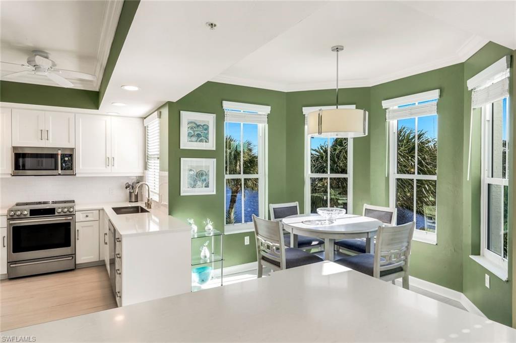 300 Dunes Boulevard, Unit 201 Naples, FL 34110 - Photo 11 of 50 a living room with furniture a large window and kitchen view