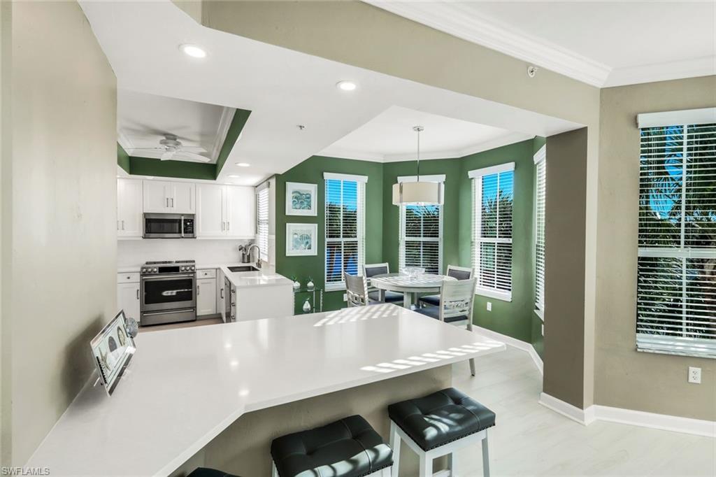 300 Dunes Boulevard, Unit 201 Naples, FL 34110 - Photo 14 of 50 a view of a living room and kitchen floor to ceiling window and stainless steel appliances