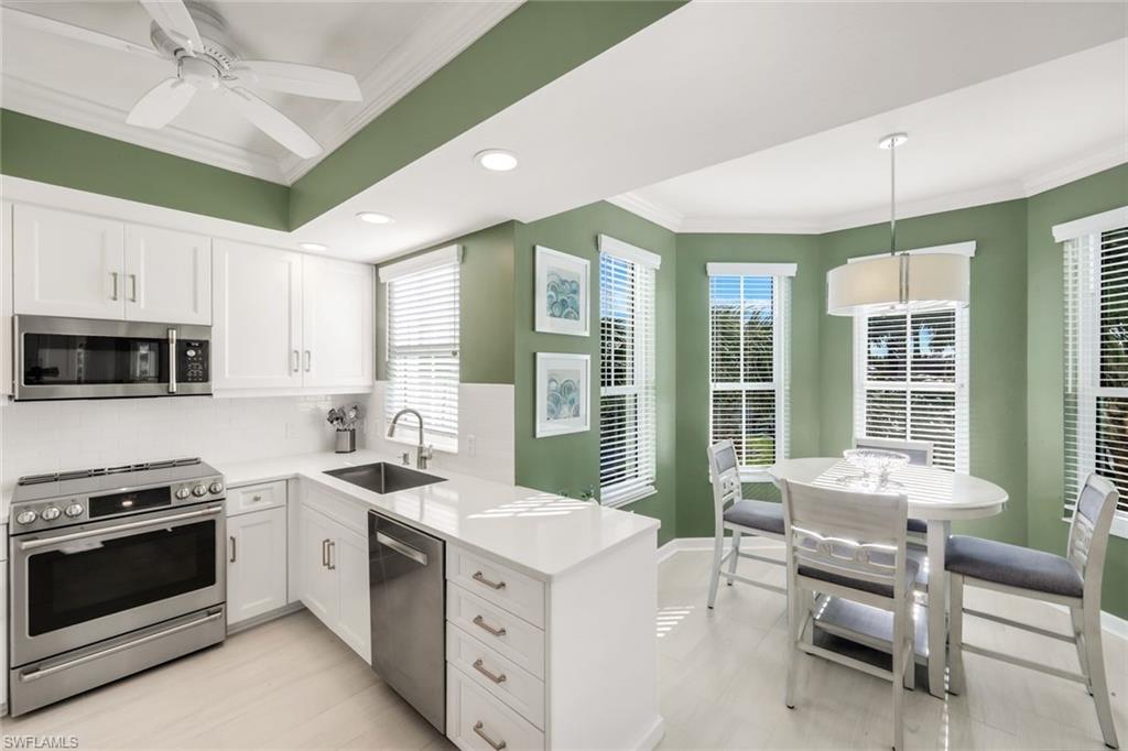 300 Dunes Boulevard, Unit 201 Naples, FL 34110 - Photo 16 of 50 a kitchen with a stove a sink and a refrigerator