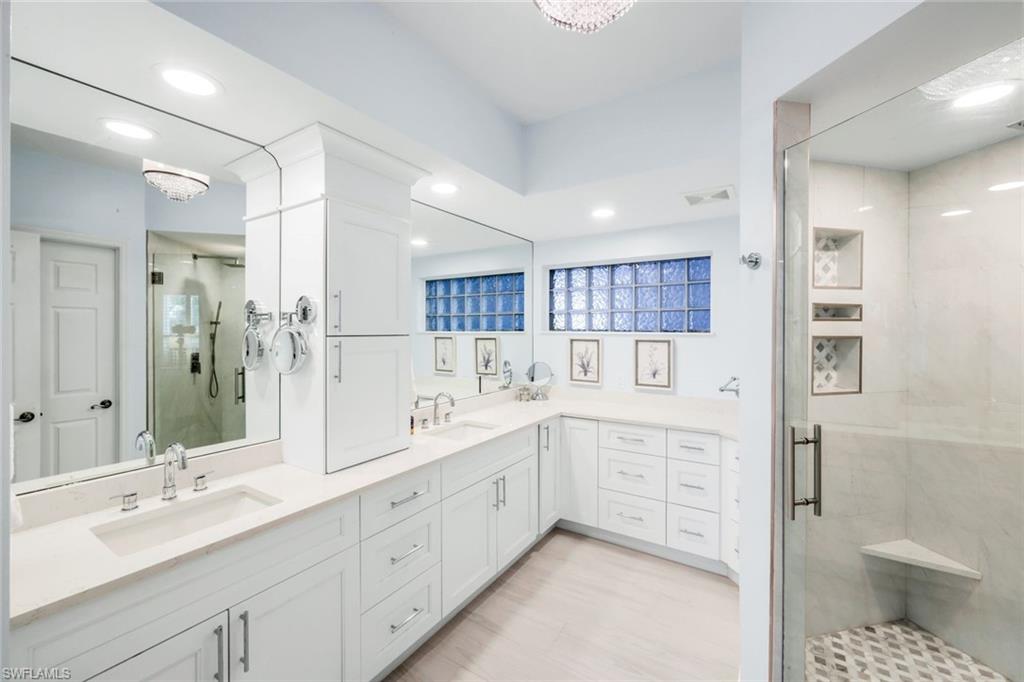300 Dunes Boulevard, Unit 201 Naples, FL 34110 - Photo 21 of 50 a spacious bathroom with a double vanity sink a mirror and a shower