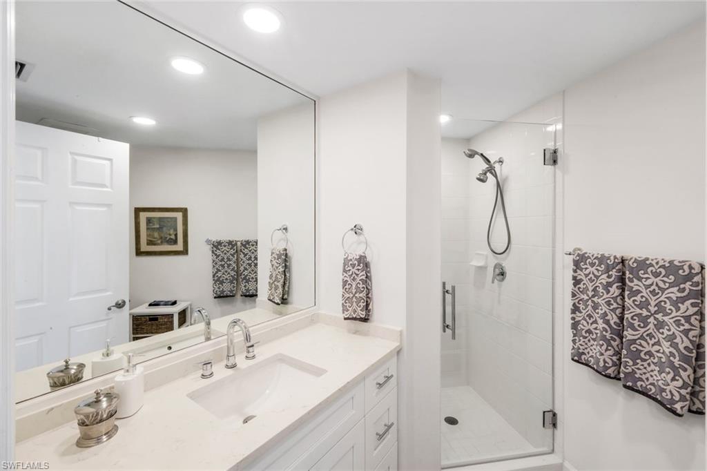 300 Dunes Boulevard, Unit 201 Naples, FL 34110 - Photo 23 of 50 a bathroom with a shower sink and mirror
