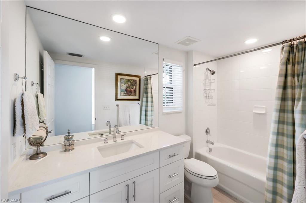 300 Dunes Boulevard, Unit 201 Naples, FL 34110 - Photo 26 of 50 a bathroom with a double vanity sink toilet mirror and shower