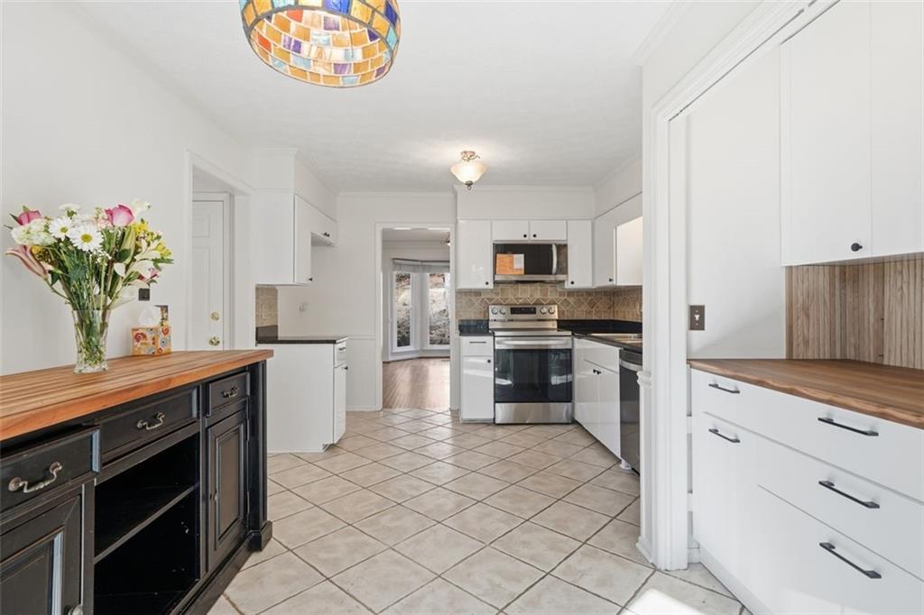 130 Spring Ridge Court Roswell, GA 30076 - Photo 15 of 47 a kitchen with white cabinets and stainless steel appliances