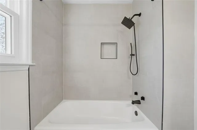 a bathroom with a bath tub with a shower