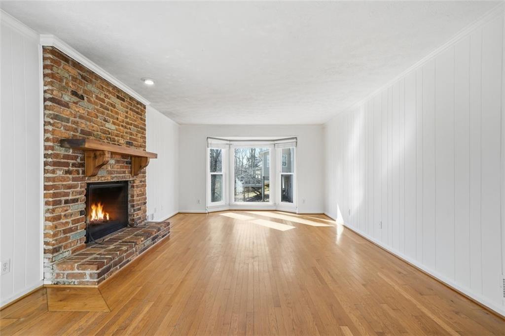 130 Spring Ridge Court Roswell, GA 30076 - Photo 6 of 47 a view of an empty room with wooden floor fireplace and a window
