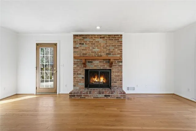 a view of an empty room with a fireplace and a window