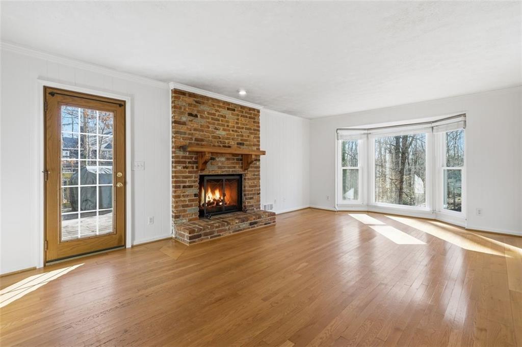 130 Spring Ridge Court Roswell, GA 30076 - Photo 8 of 47 a view of an empty room with wooden floor fireplace and a window
