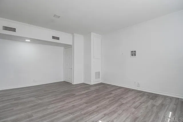 a view of an empty room with wooden floor