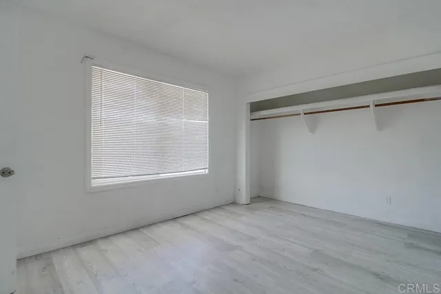 a view of an empty room with a window and closet area