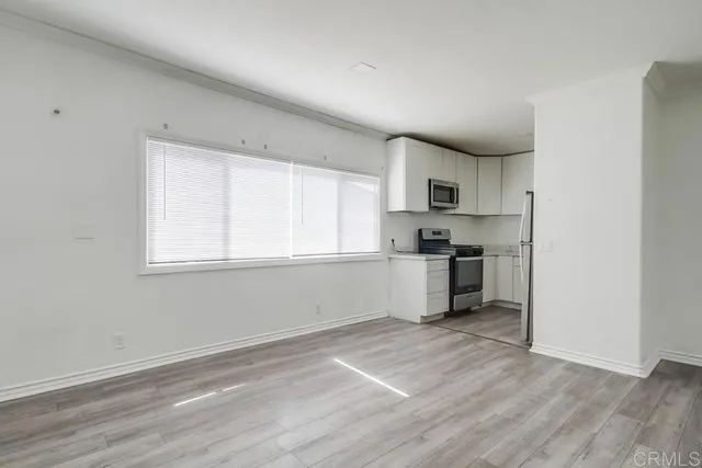 a kitchen with granite countertop a stove a sink and a refrigerator