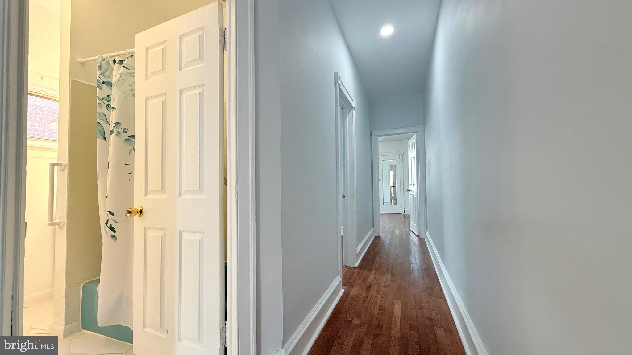 1333 Colwyn Street Philadelphia, PA 19140 - Photo 13 of 38 a view of a hallway with wooden floor and a bathroom