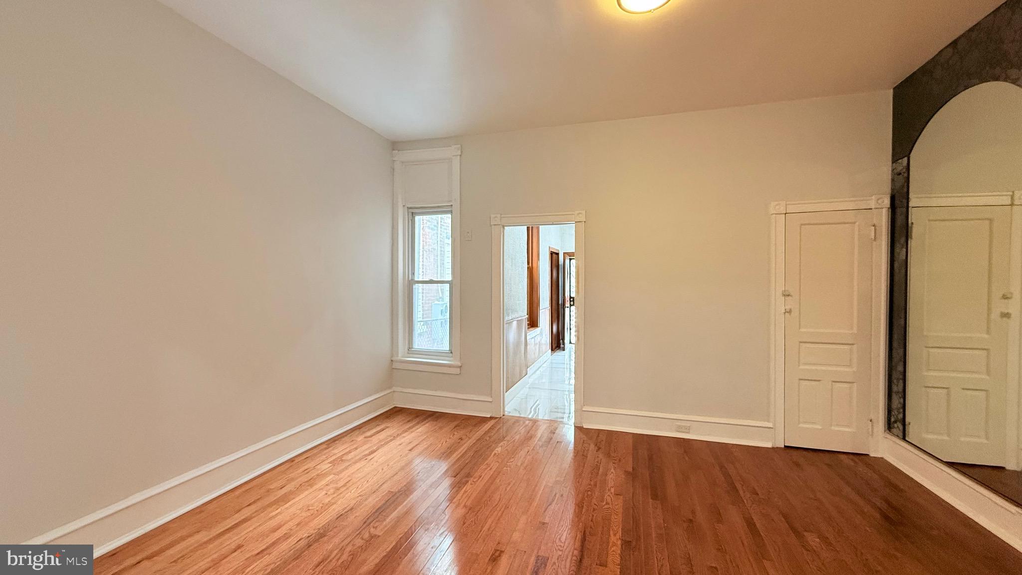 1333 Colwyn Street Philadelphia, PA 19140 - Photo 7 of 38 wooden floor in an empty room with a window