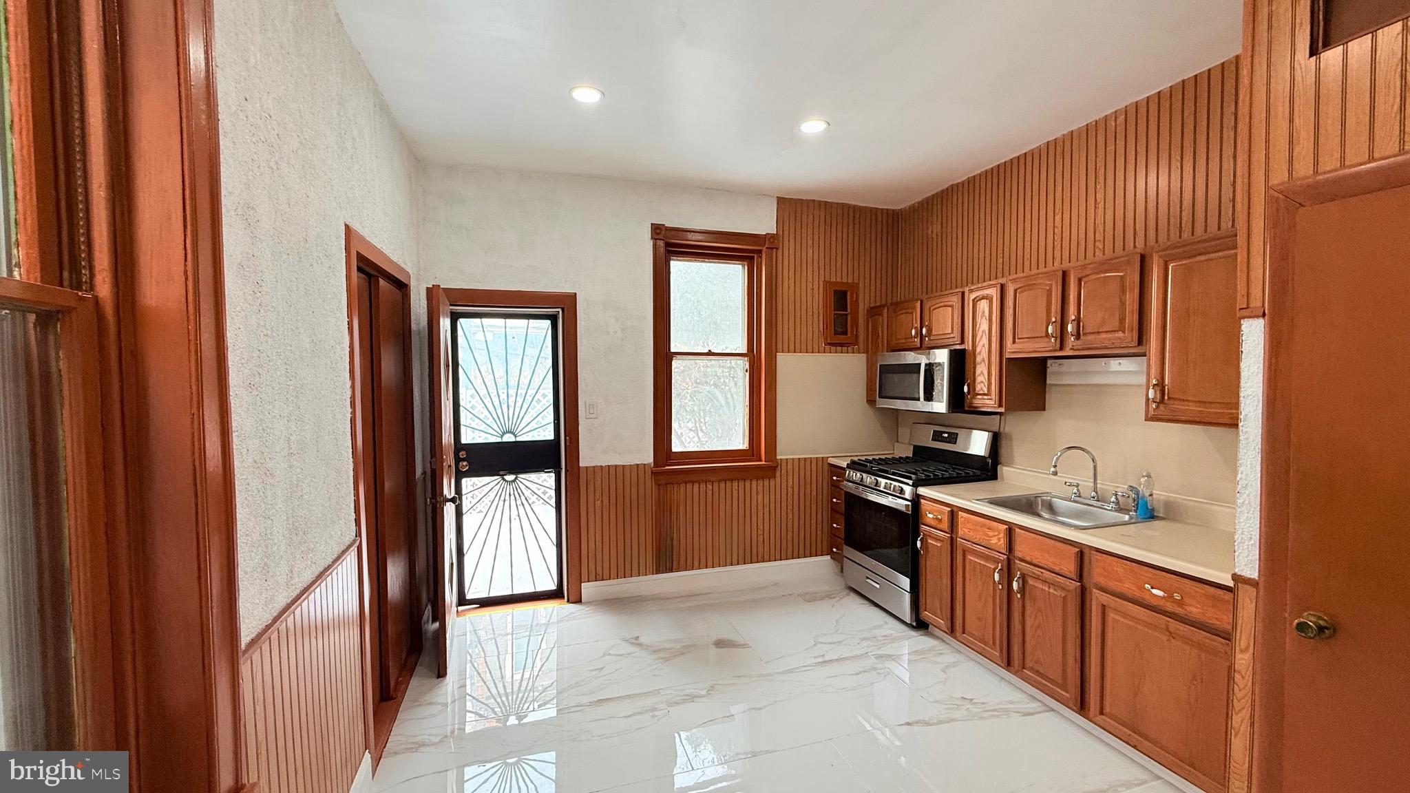 1333 Colwyn Street Philadelphia, PA 19140 - Photo 9 of 38 a kitchen with stainless steel appliances granite countertop a refrigerator and a sink