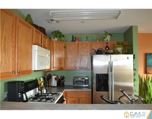 358 Rector Street, Unit 501 Perth Amboy, NJ 08861 - Photo 13 of 25 a kitchen with a refrigerator a stove and a microwave oven
