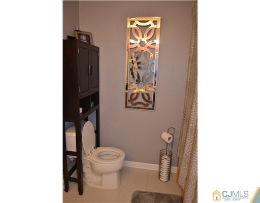 358 Rector Street, Unit 501 Perth Amboy, NJ 08861 - Photo 19 of 25 a bathroom with a toilet and a shower curtain