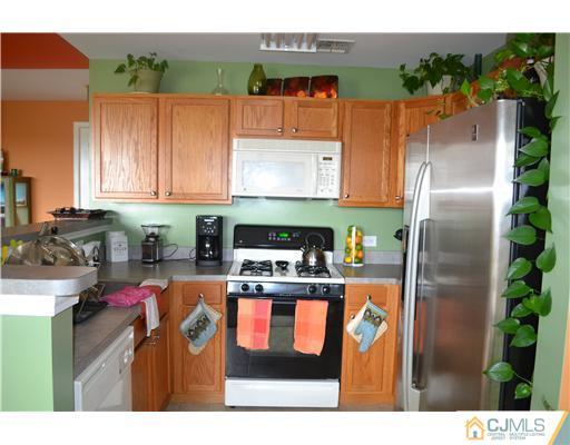 358 Rector Street, Unit 501 Perth Amboy, NJ 08861 - Photo 8 of 25 a kitchen with stainless steel appliances granite countertop a refrigerator a stove and a microwave