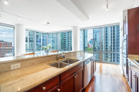 a kitchen with stainless steel appliances granite countertop a stove a microwave and wooden cabinets