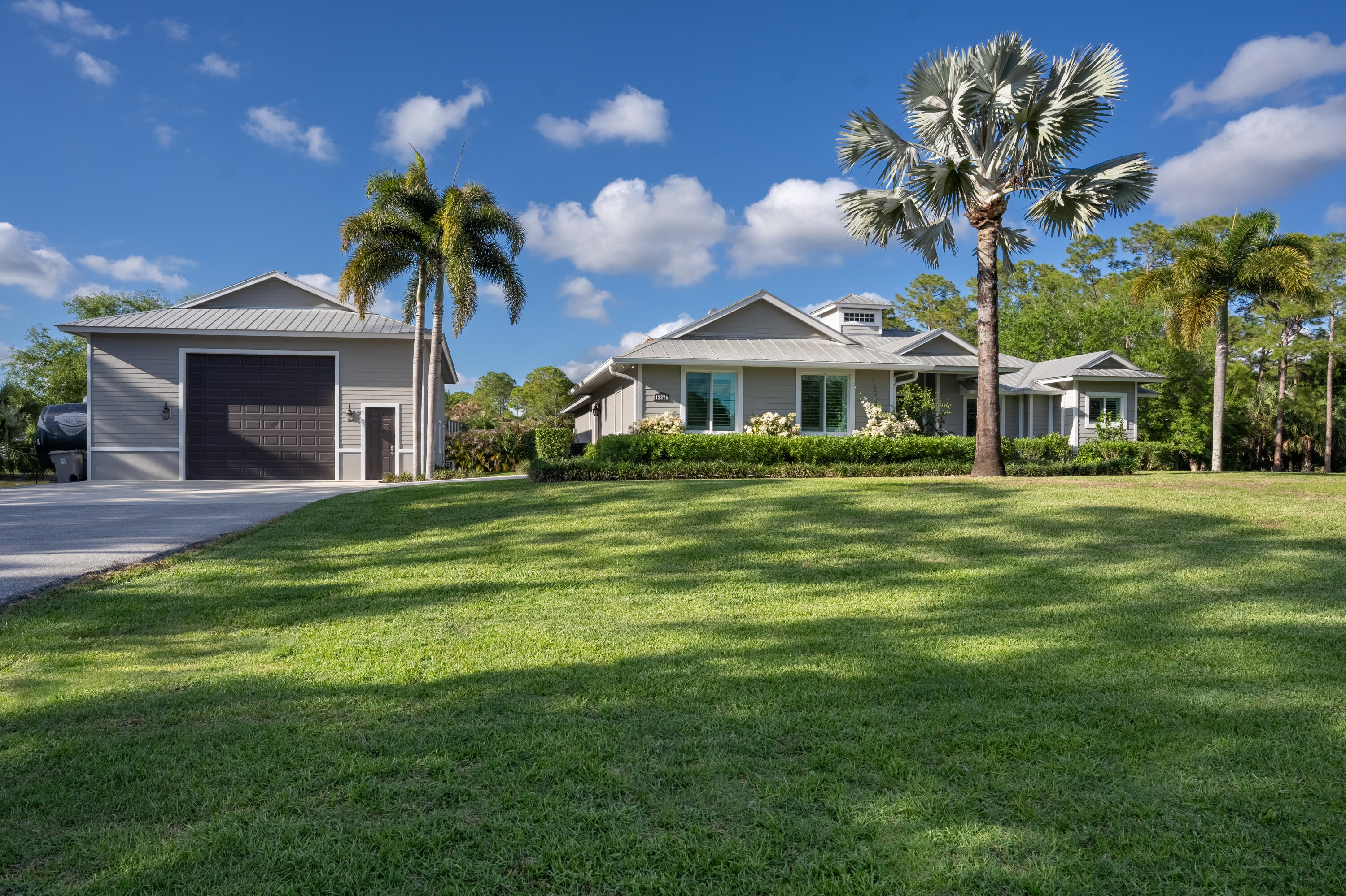 12275 185th Street North Jupiter, FL 33478 - Photo 1 of 35 a front view of a house with a garden