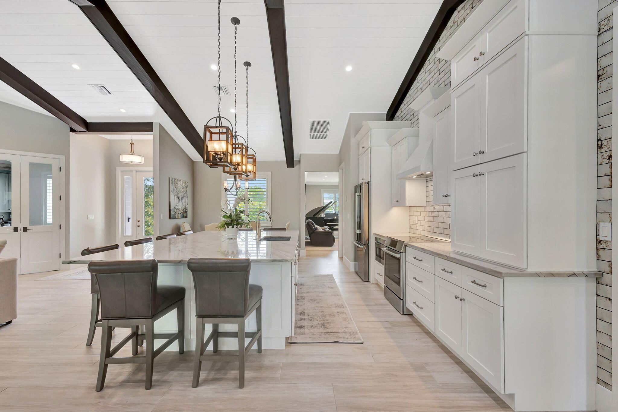 12275 185th Street North Jupiter, FL 33478 - Photo 11 of 35 a kitchen with stainless steel appliances kitchen island granite countertop lots of white cabinets and wooden floors