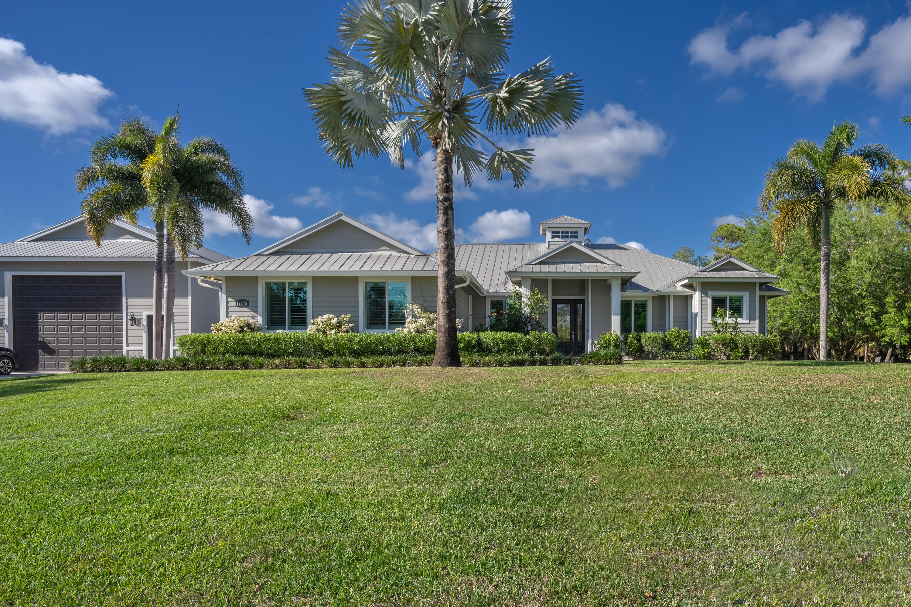 12275 185th Street North Jupiter, FL 33478 - Photo 4 of 35 a front view of a house with a garden