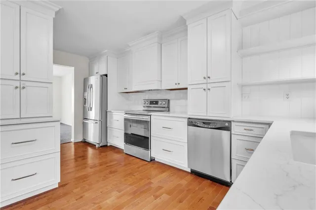 a kitchen with white cabinets and stainless steel appliances
