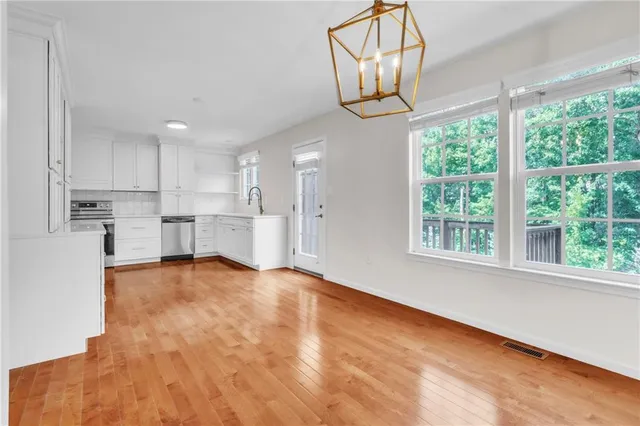 a view of kitchen with stainless steel appliances granite countertop cabinets and a chandelier