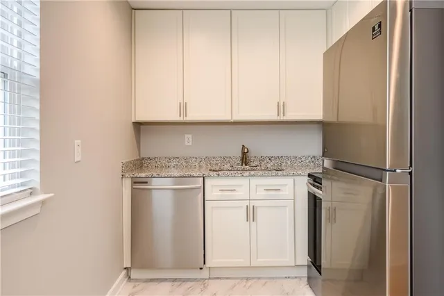 a kitchen with stainless steel appliances granite countertop a refrigerator sink and cabinets