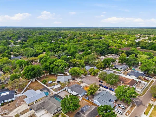 an aerial view of residential houses with outdoor space and trees